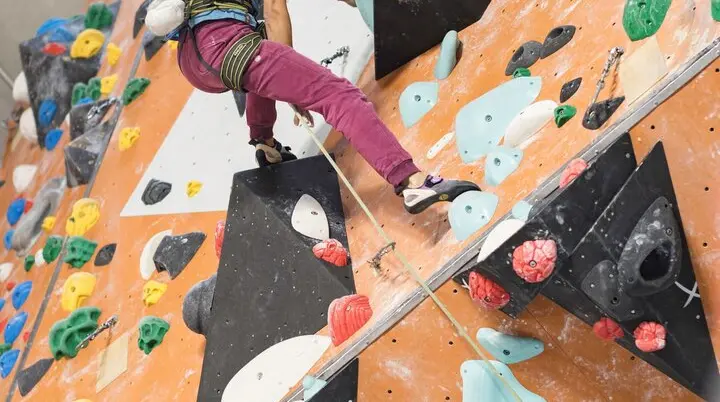 Eine Frau hochkonzentriert in einer Kletteranlage | © DAV / Jens Klatt